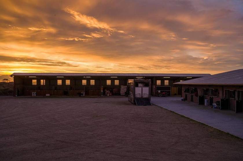 Ado McGuinness's yard at sunrise, with the covered barn and stable block